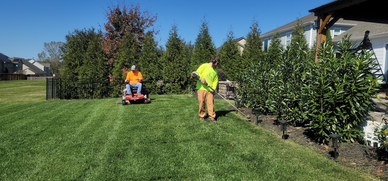 Lawn maintenance in progress with clean edging and fresh cut grass