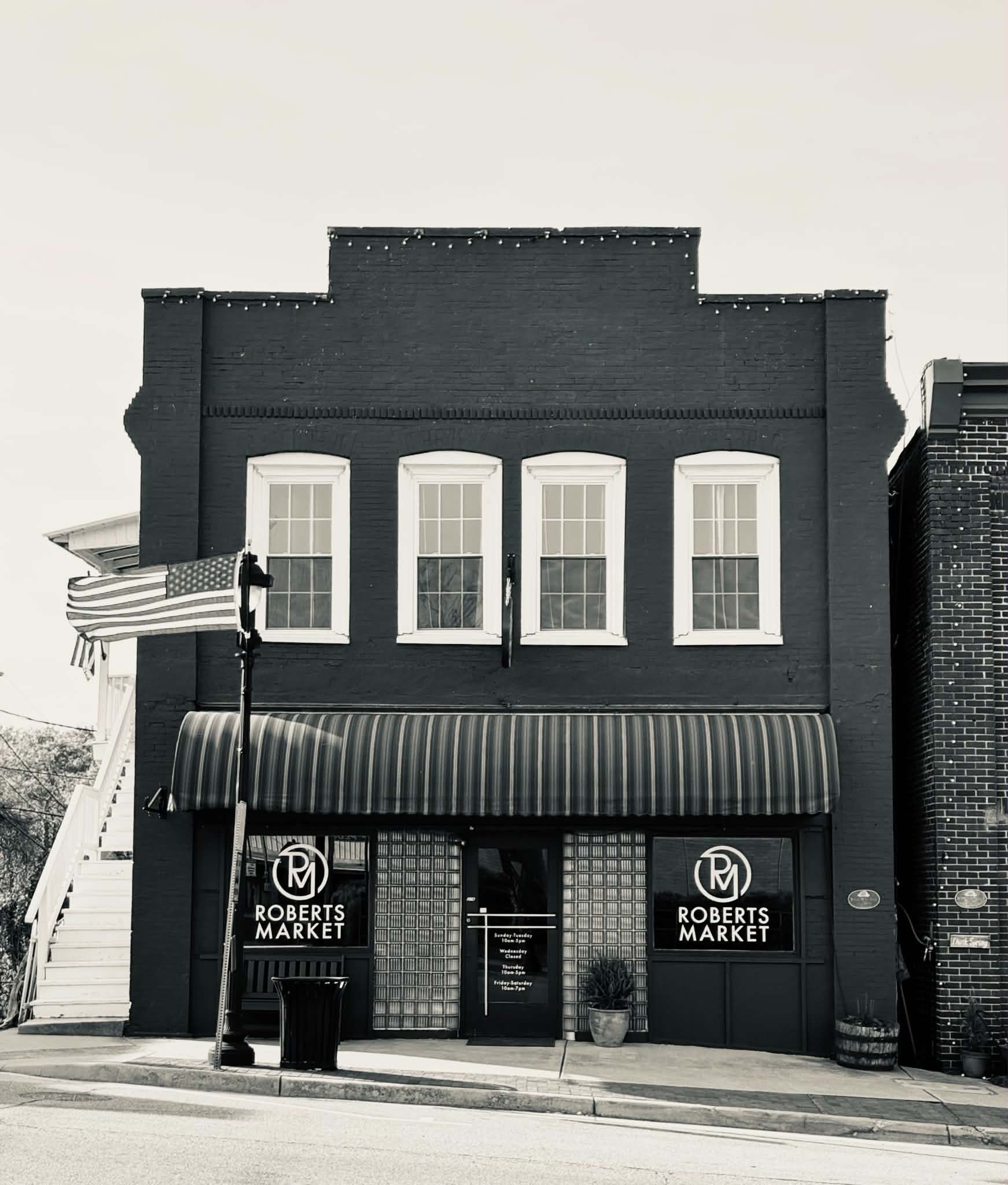 Roberts Market today — black-and-white photo of the brick storefront with striped awning at 216 Virginia Avenue